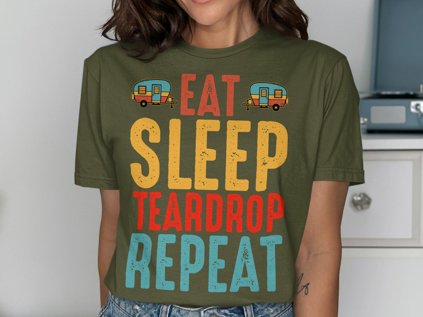Green t-shirt with "EAT SLEEP TEARDROP REPEAT" text and small camper illustrations.