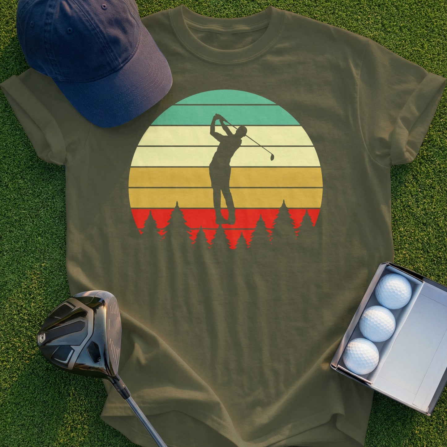 Golfer swinging at sunset with trees, on olive green t-shirt.