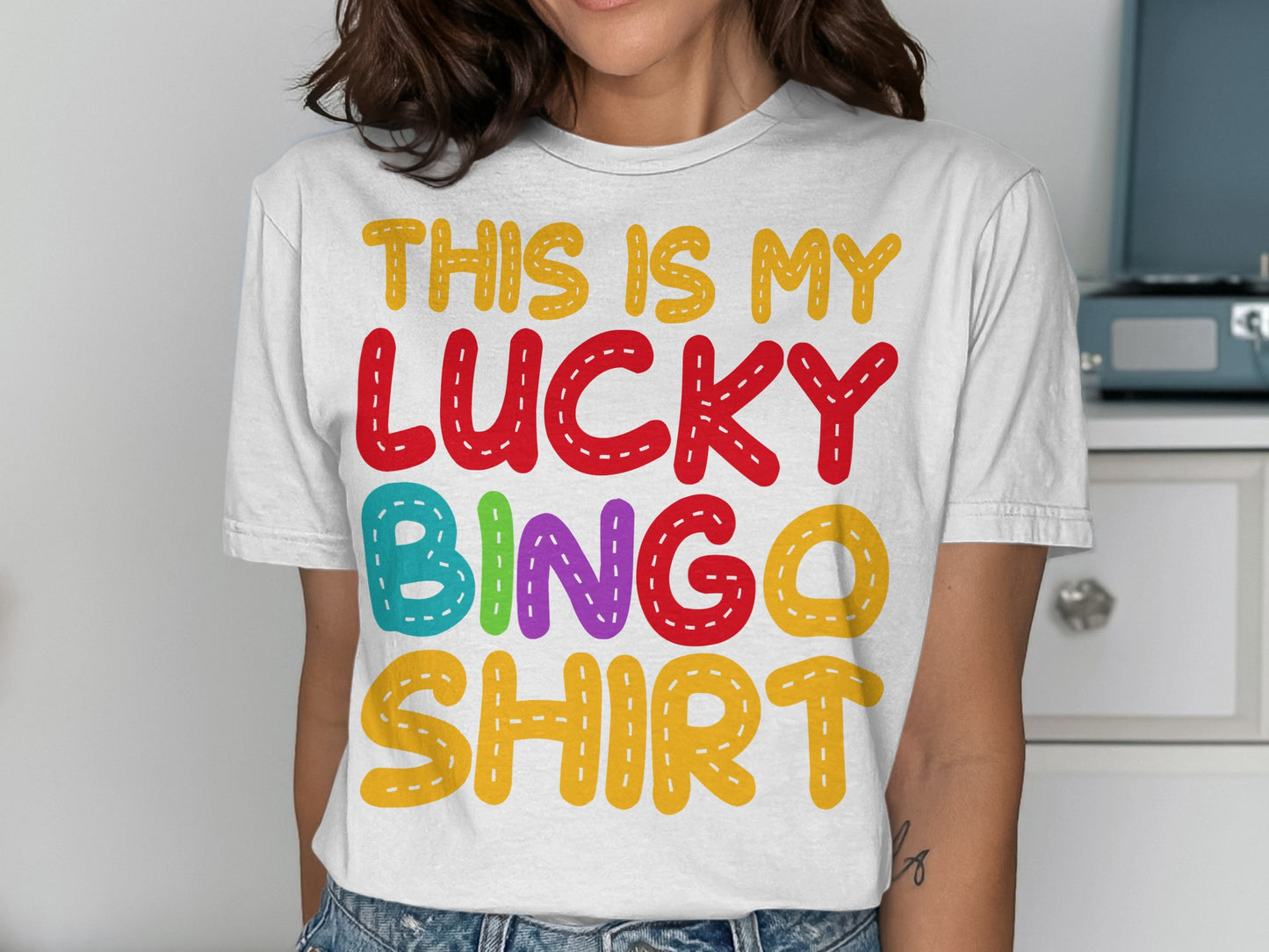 White t-shirt with "THIS IS MY LUCKY BINGO SHIRT" text in colorful letters.