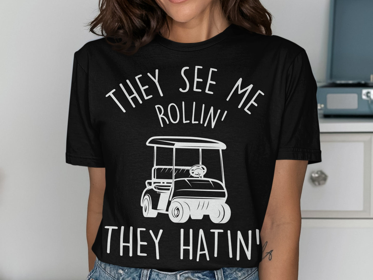 Black t-shirt with white text and graphic of a golf cart.