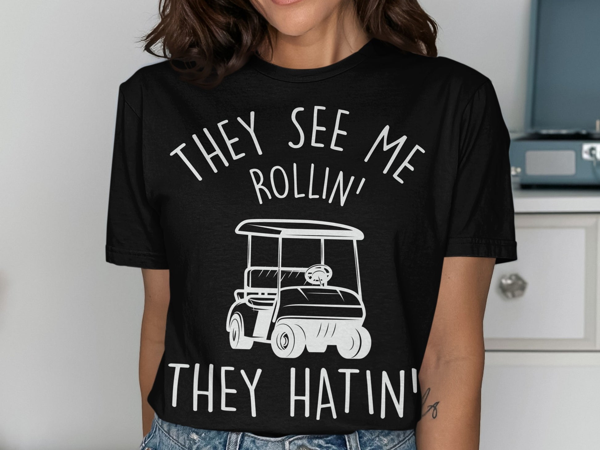 Black t-shirt with white text and graphic of a golf cart.