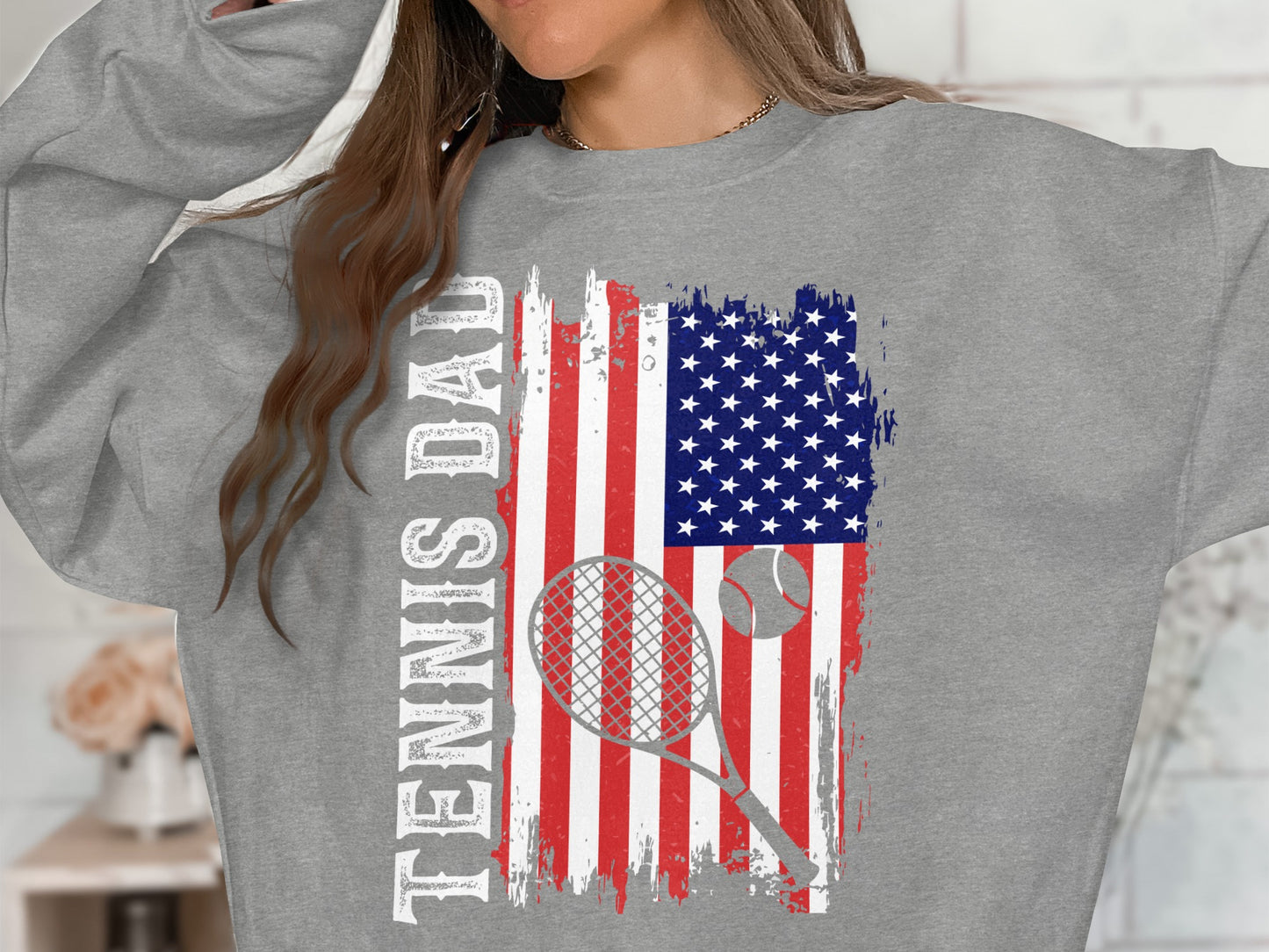 Gray sweatshirt with distressed American flag, tennis racket, and tennis ball graphic.