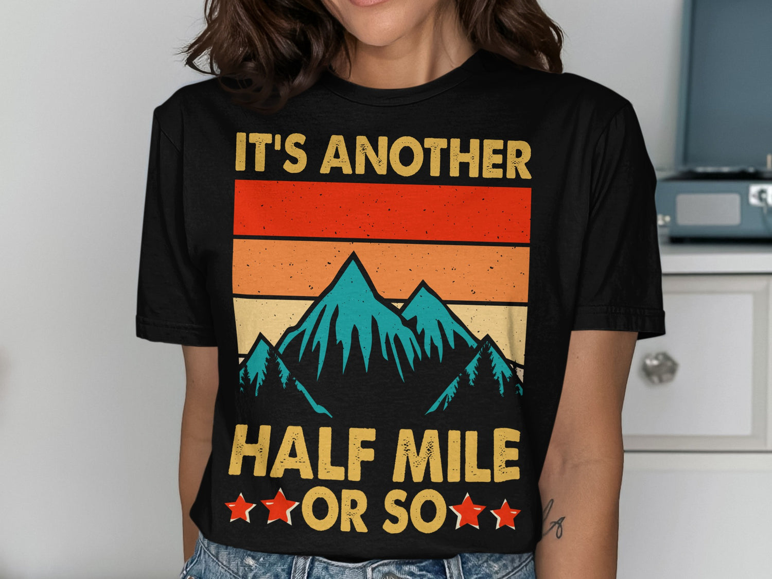 Black t-shirt with "IT'S ANOTHER HALF MILE OR SO" and mountain graphic.