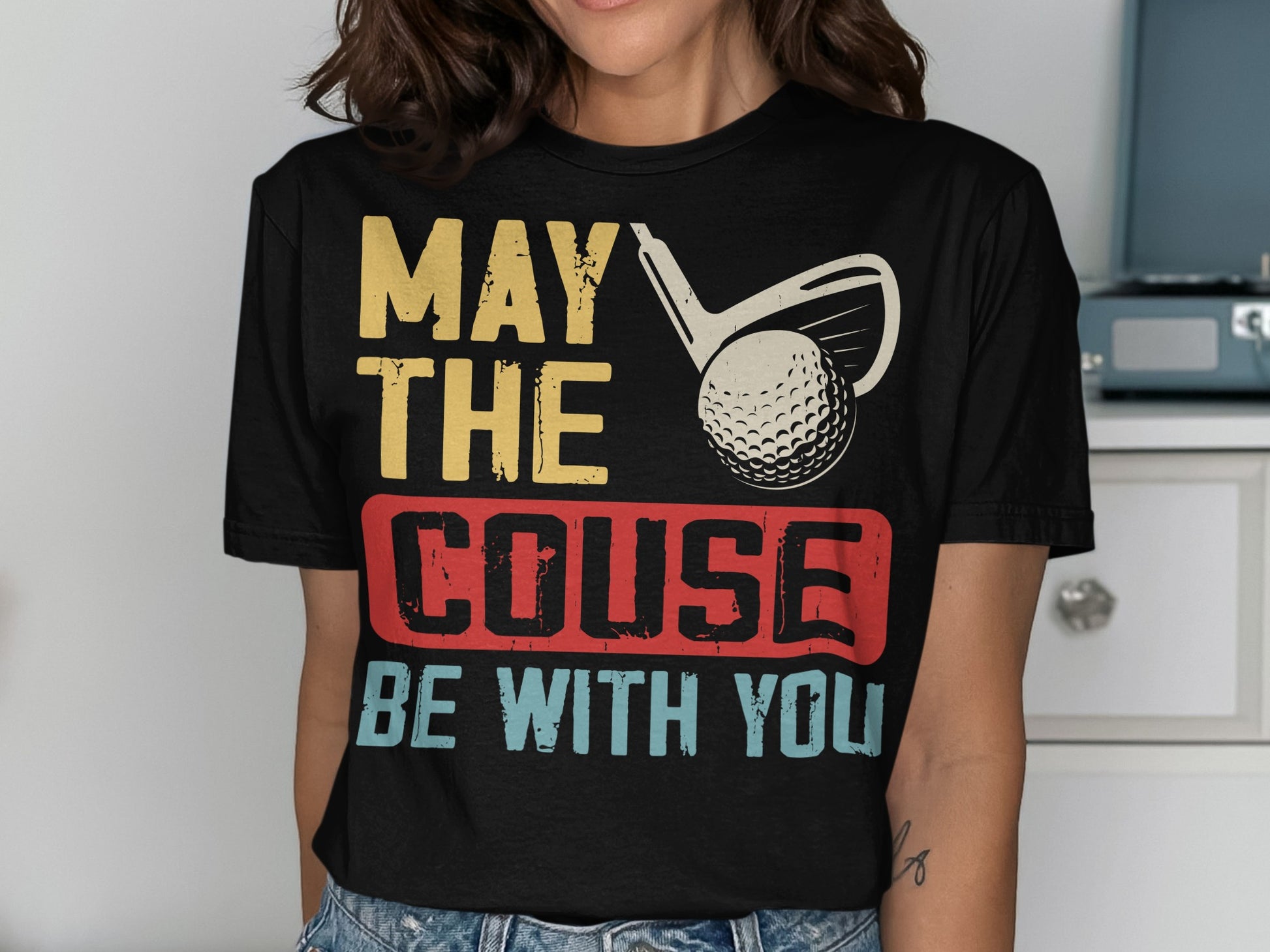 T-shirt with "May the couse be with you" text, golf club, and ball.