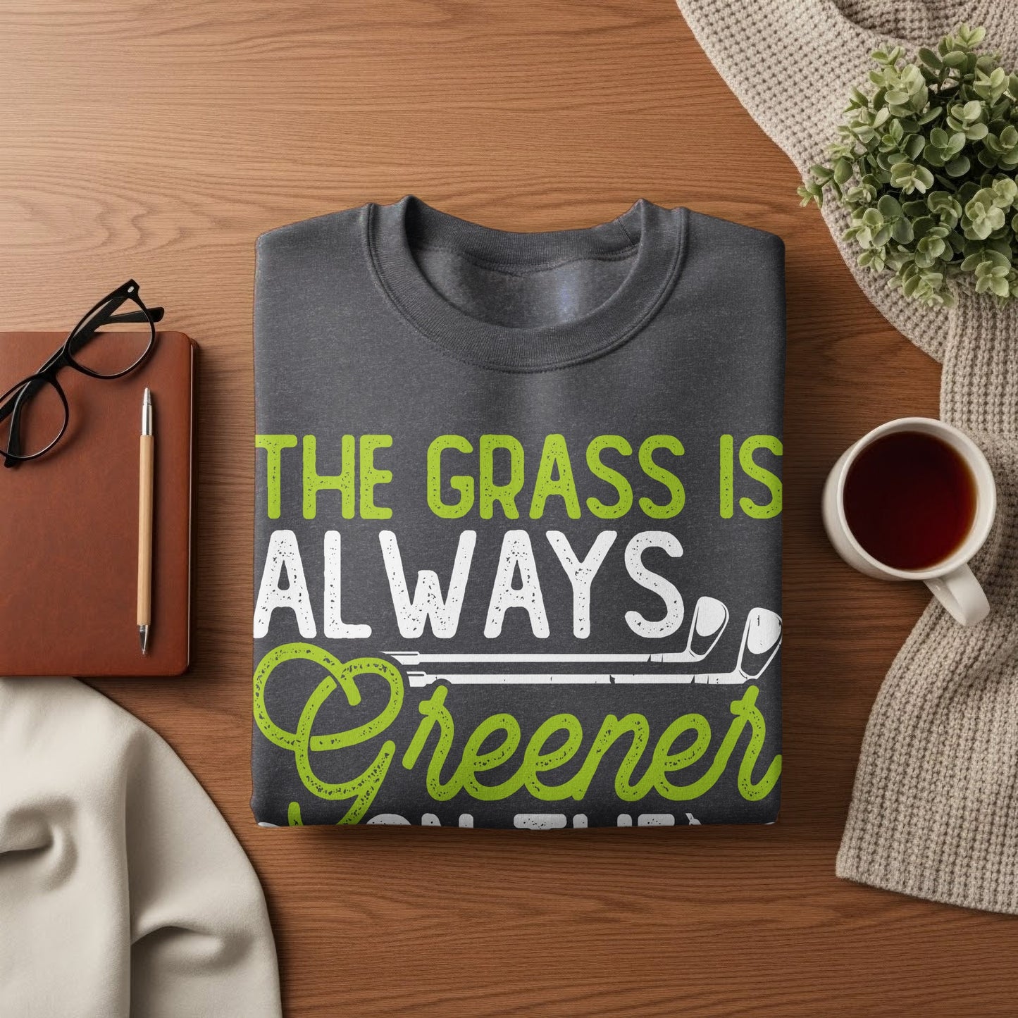Charcoal gray sweatshirt with "The grass is always greener" text and golf club graphic.
