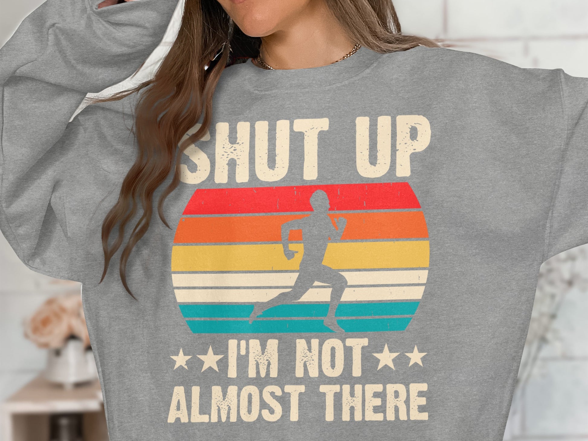 Gray sweatshirt with runner graphic and text: "SHUT UP I'M NOT ALMOST THERE".