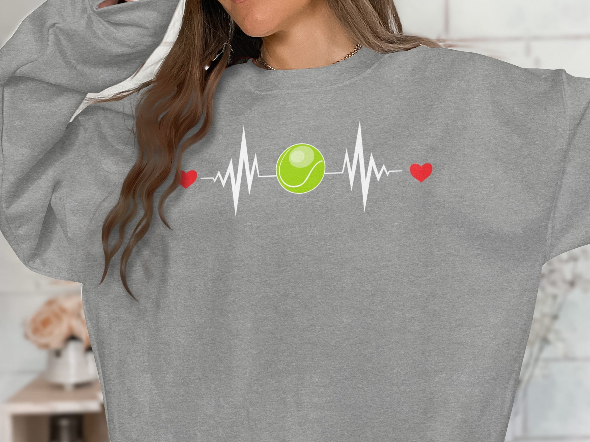 Grey sweatshirt with a white heartbeat line, tennis ball, and red hearts graphic.