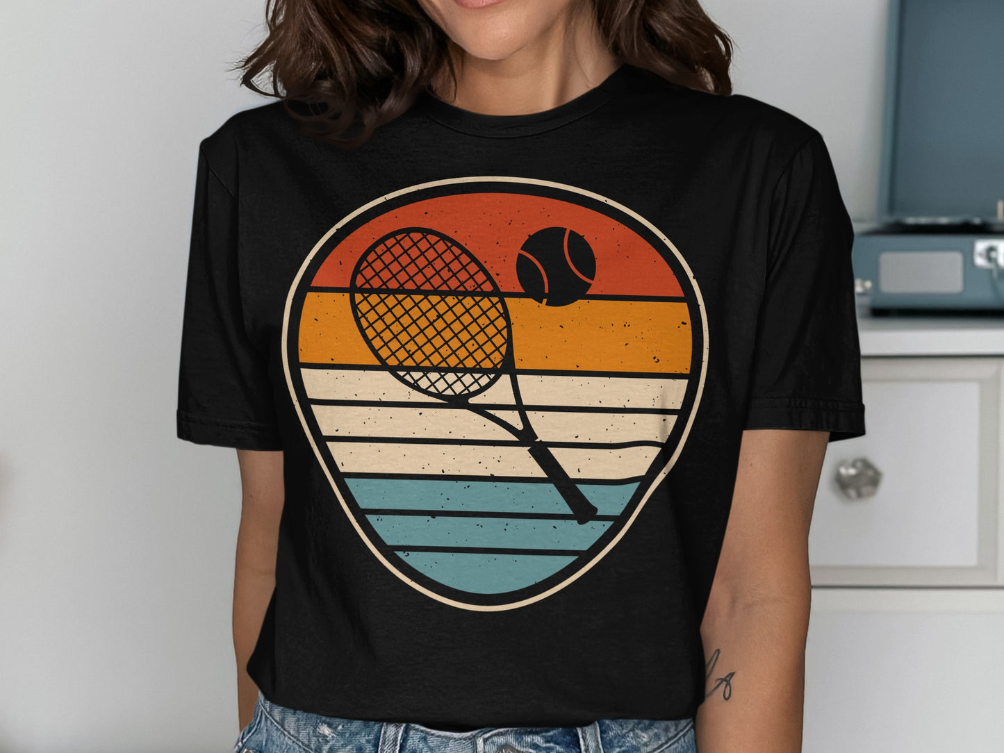 Tennis racket and ball in a circular retro graphic on a black t-shirt.