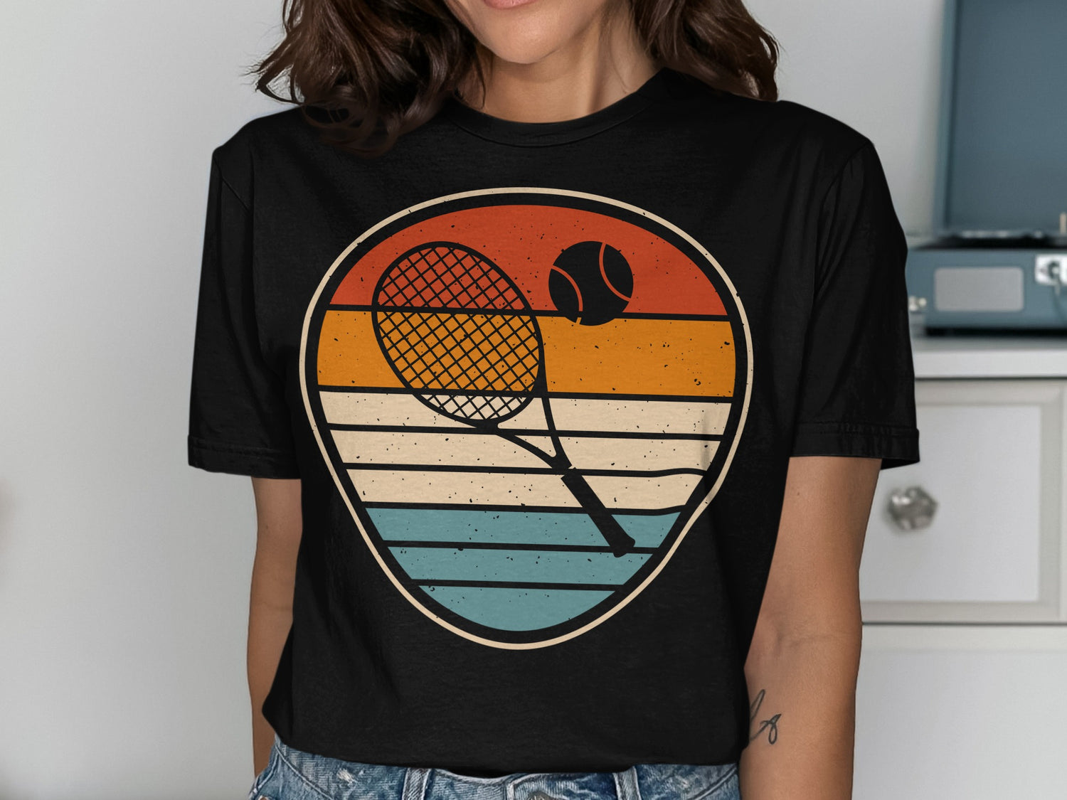 Tennis racket and ball in a circular retro graphic on a black t-shirt.