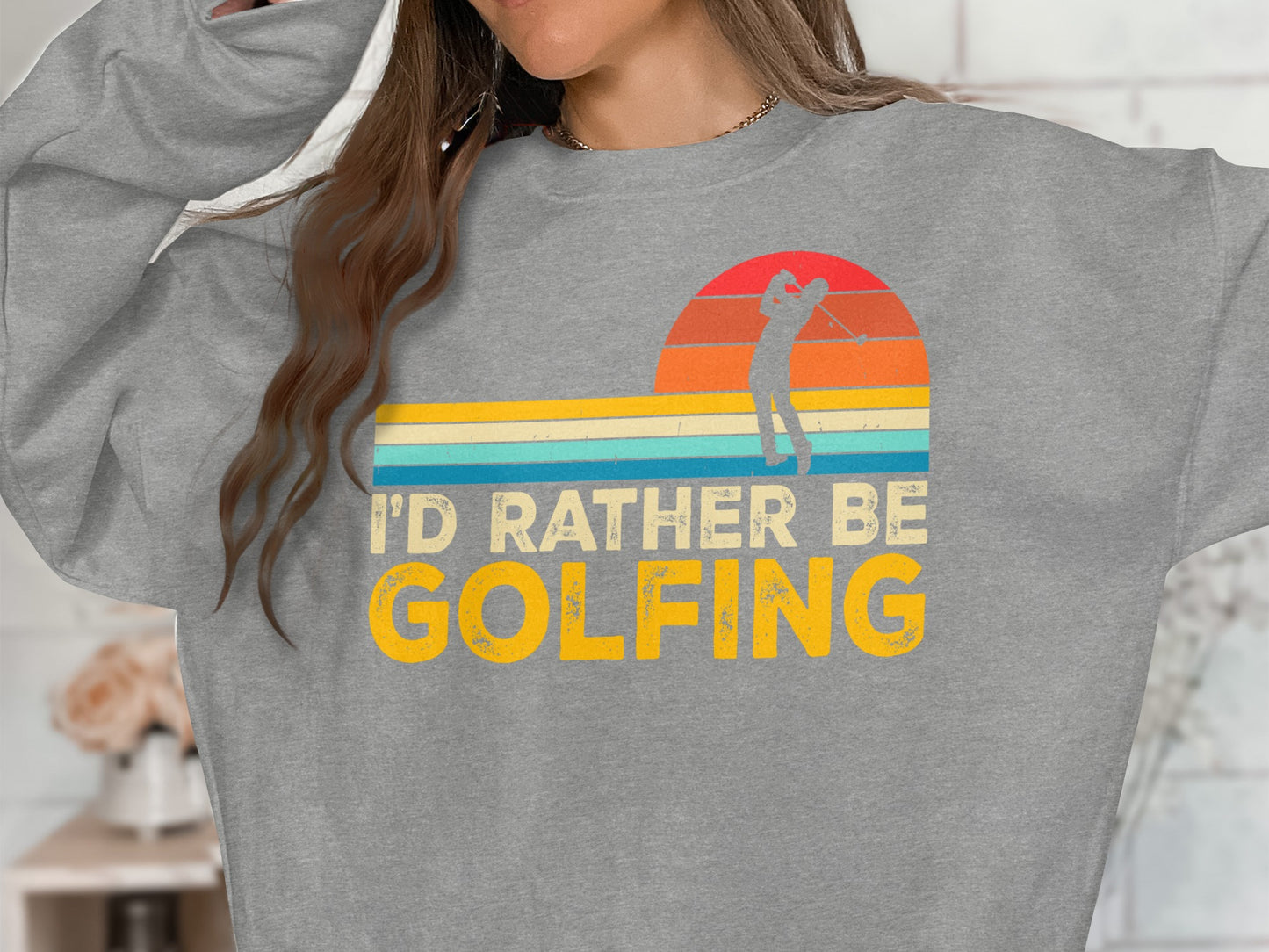 Grey sweatshirt with "I'd Rather Be Golfing" text and sunset graphic.