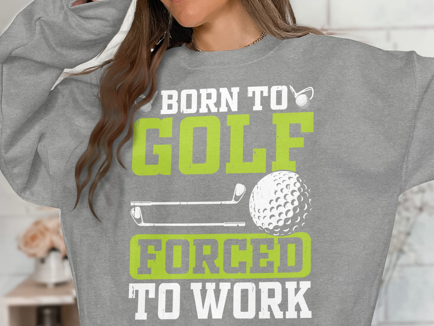 Grey sweatshirt with "Born to Golf, Forced to Work" text and golf graphics.