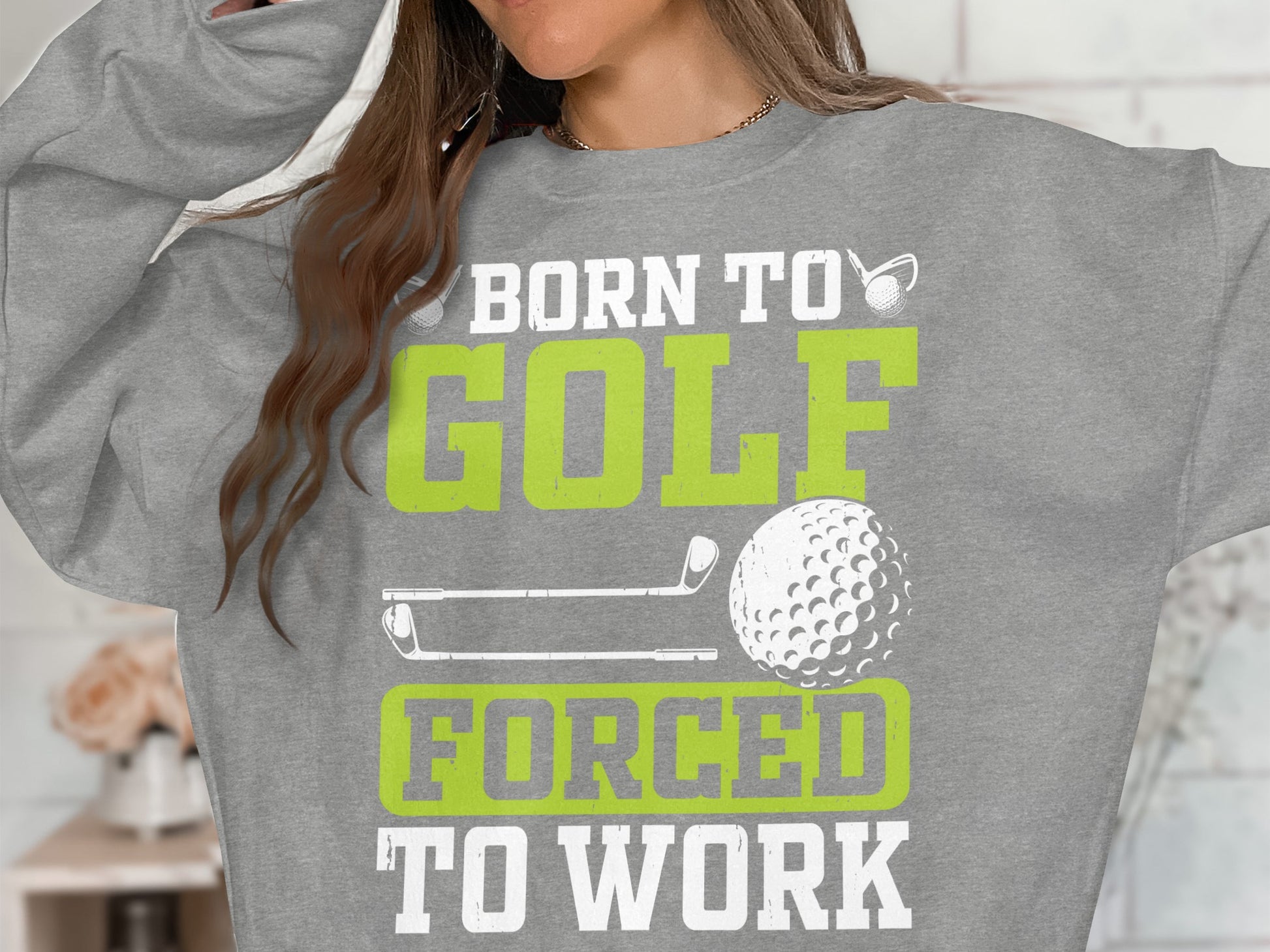 Grey sweatshirt with "Born to Golf, Forced to Work" text and golf graphics.