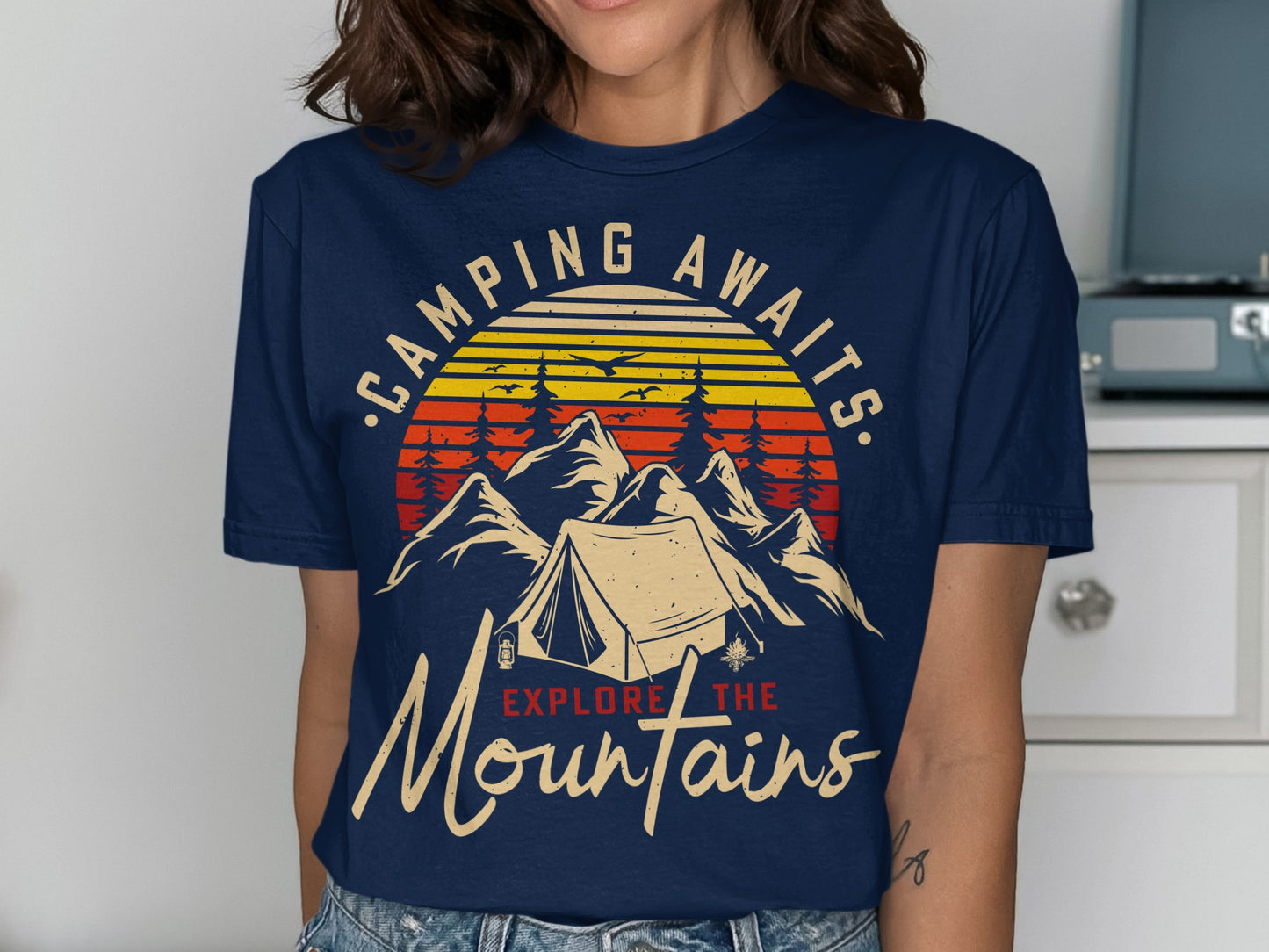 T-shirt with sunset, mountains, tent, and text "Camping awaits. Explore the Mountains."