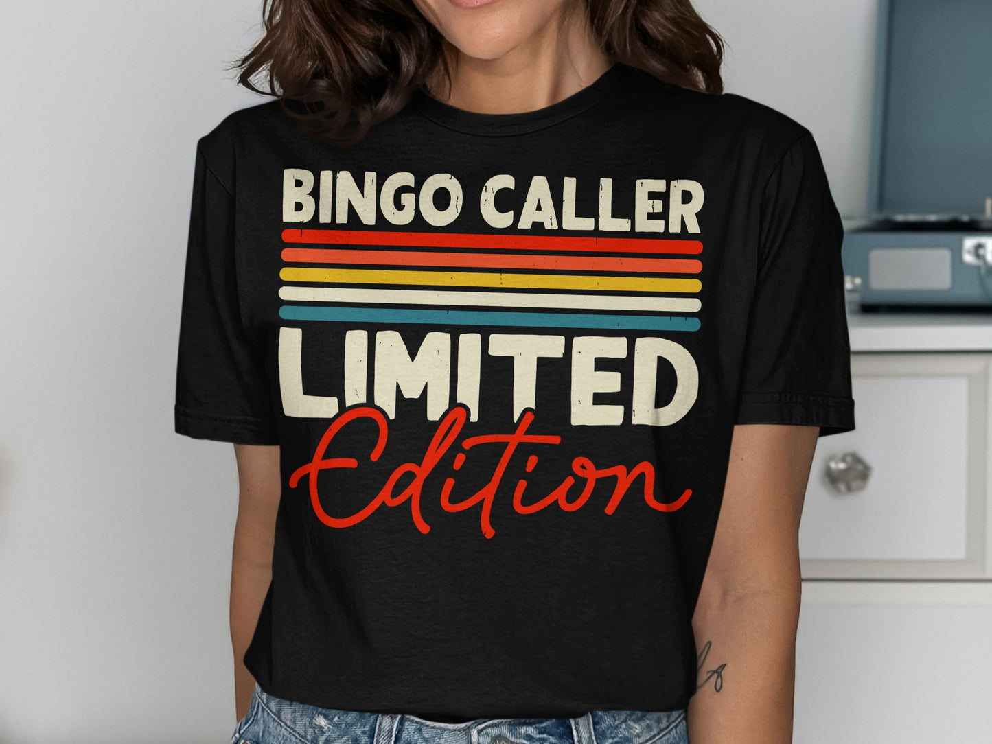Black t-shirt with "BINGO CALLER LIMITED EDITION" in colorful stripes and red script.