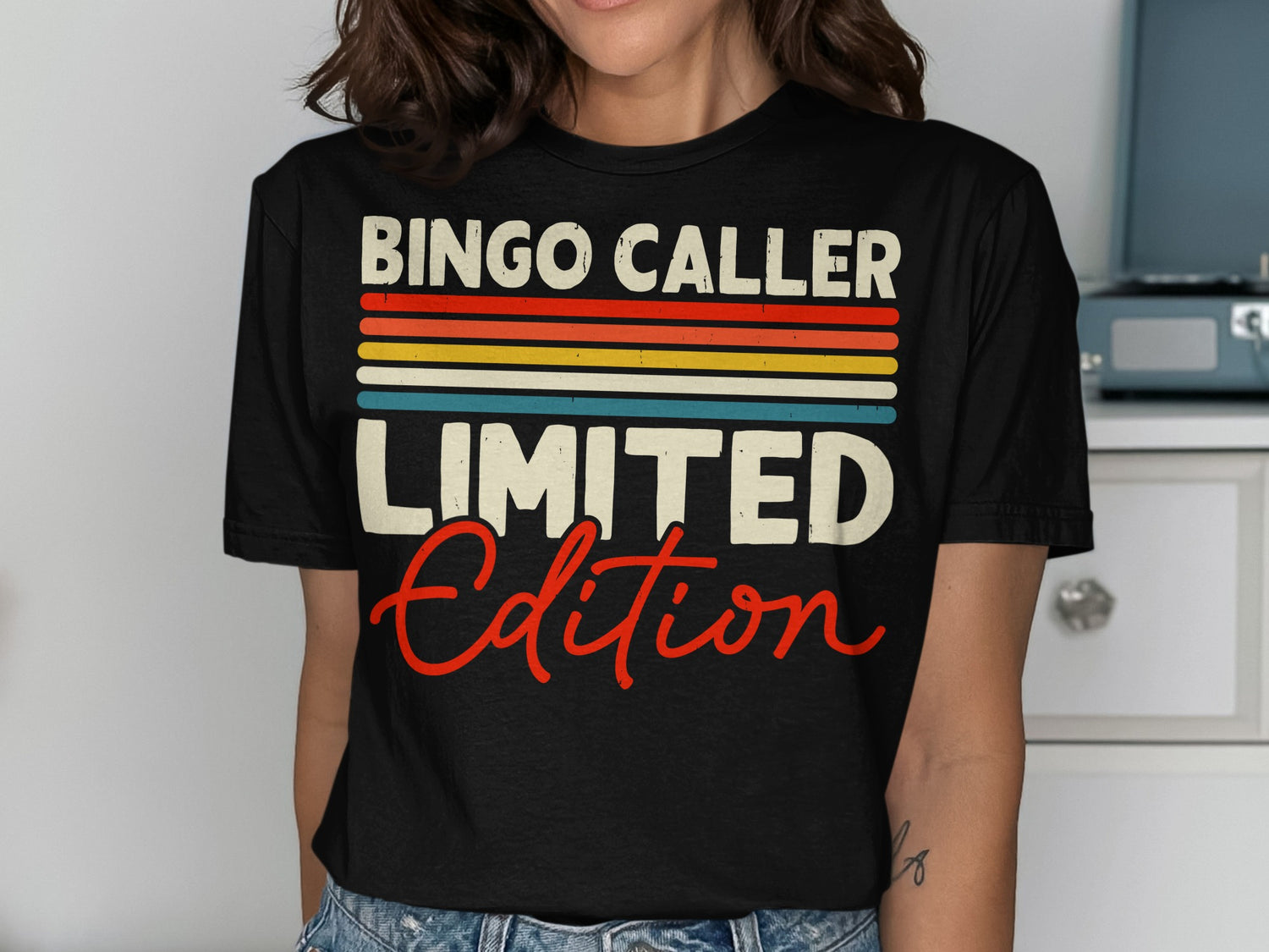 Black t-shirt with "BINGO CALLER LIMITED EDITION" in colorful stripes and red script.