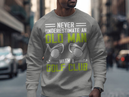 Gray sweatshirt with "Never Underestimate an Old Man with a Golf Club" text and golf balls.