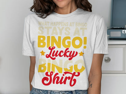 White t-shirt with "What Happens at Bingo Stays at Bingo!" in yellow text.