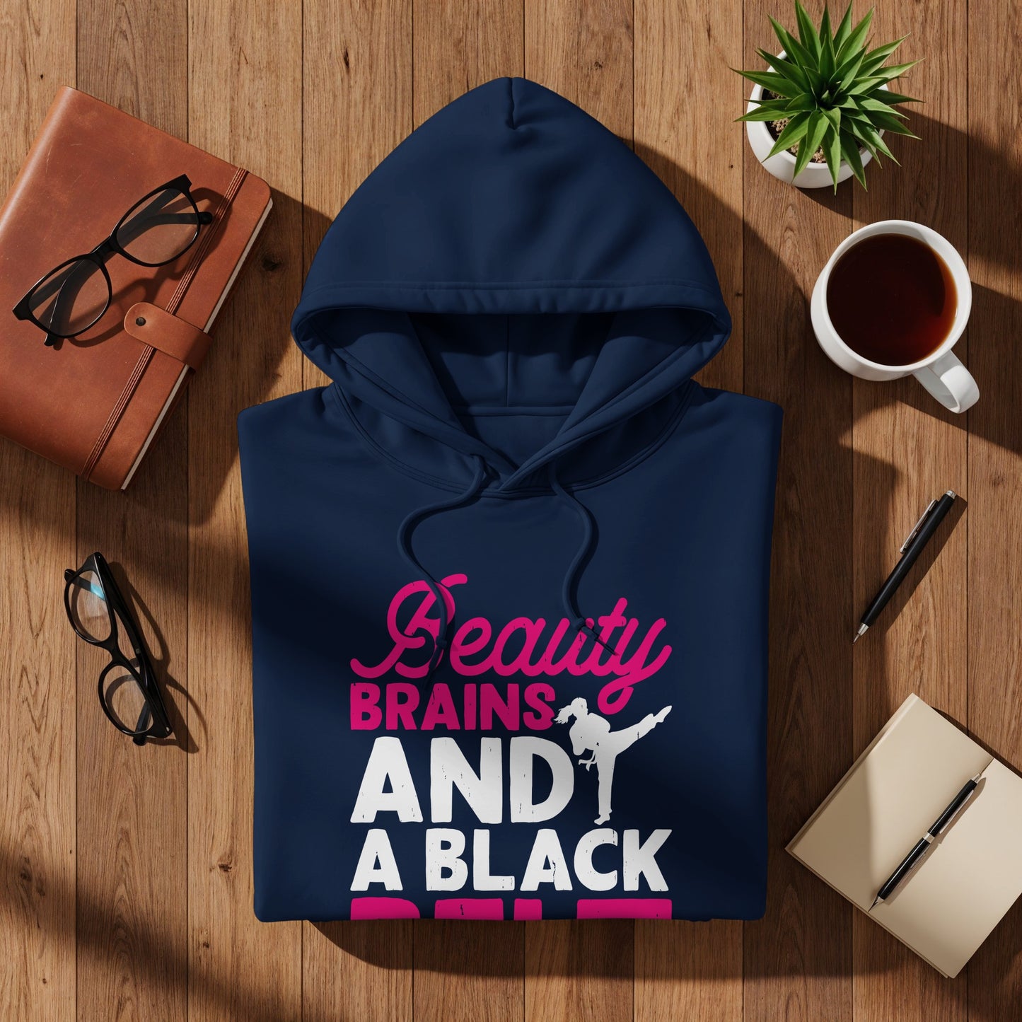 Dark blue hoodie with "Beauty BRAINS AND A BLACK BELT" text and martial artist graphic.