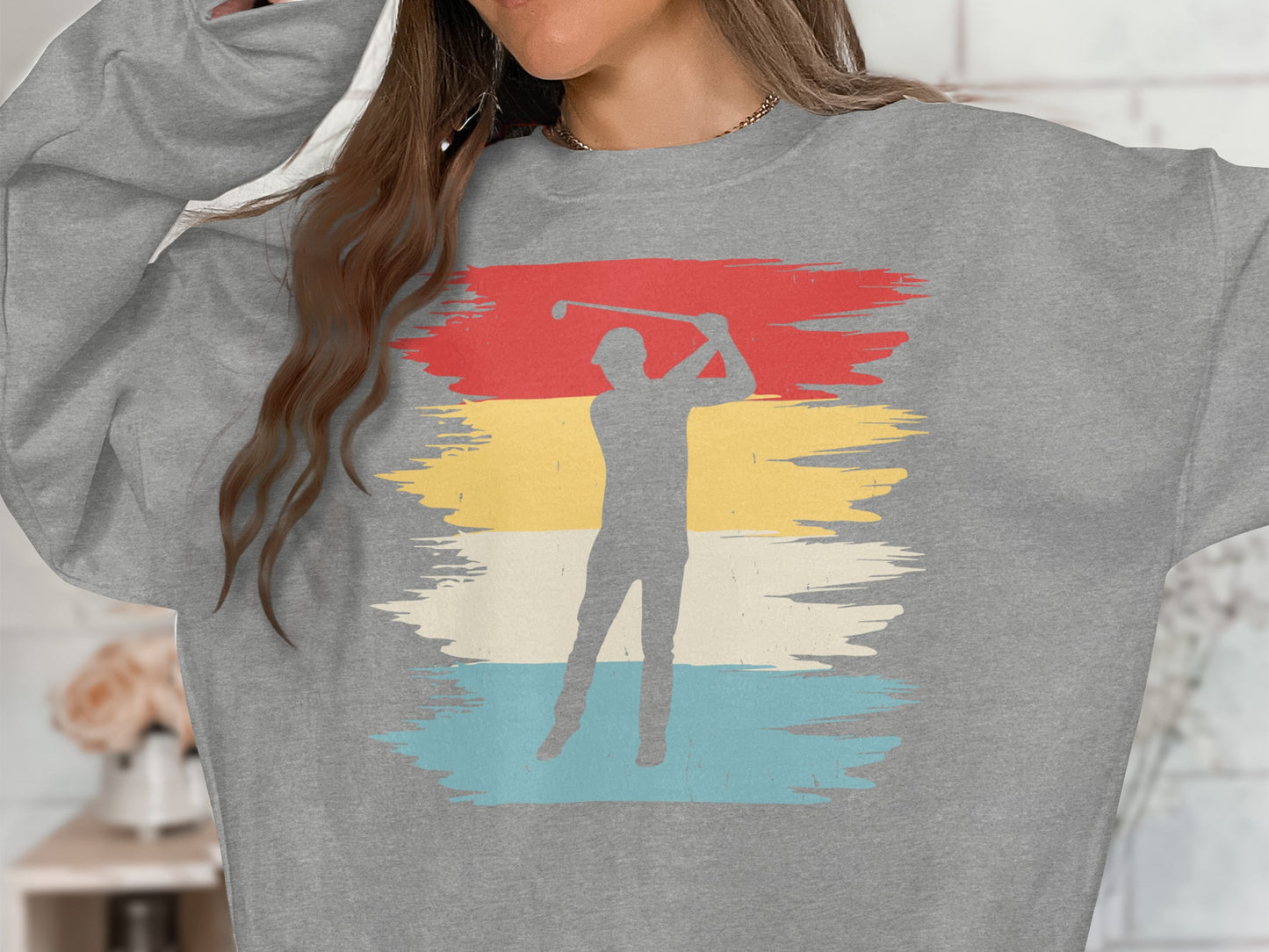 Gray sweatshirt with a golfer silhouette on a distressed multi-color stripe background.