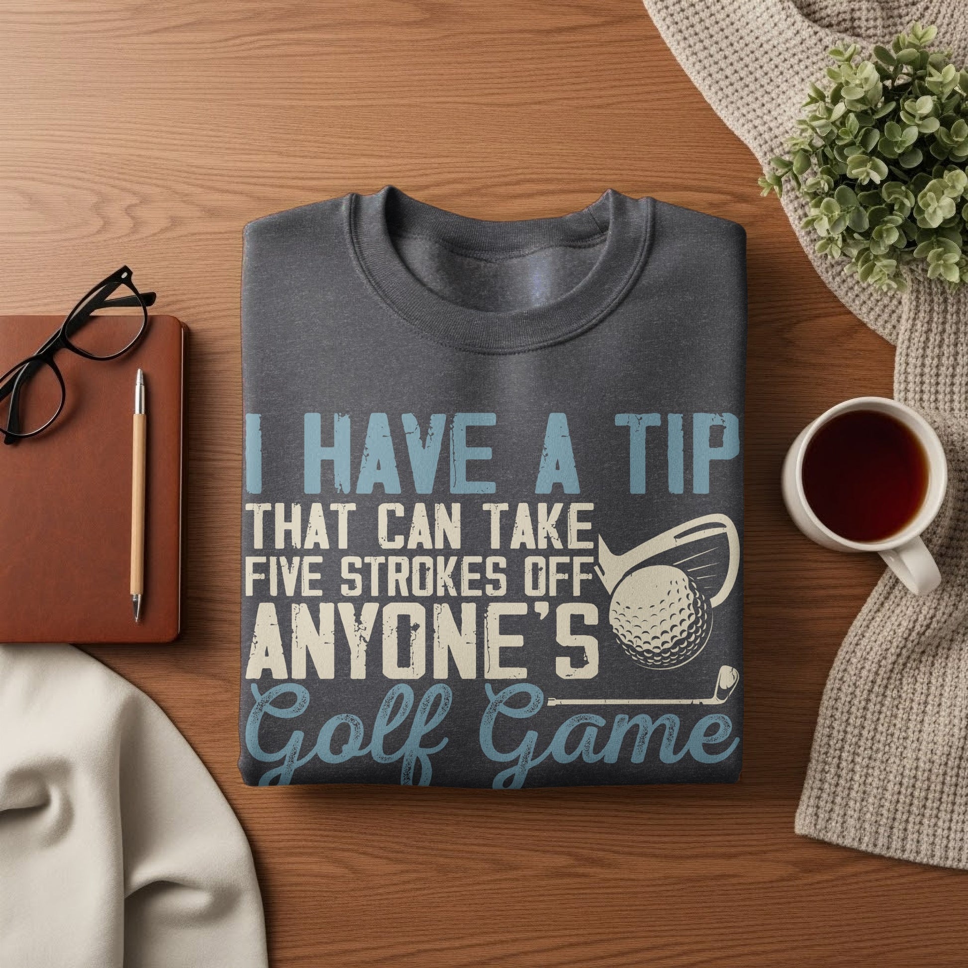 Dark gray t-shirt with text "I HAVE A TIP THAT CAN TAKE FIVE STROKES OFF ANYONE'S Golf Game."