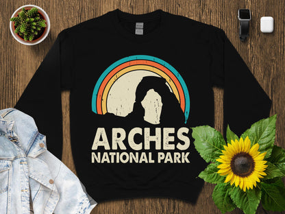 Black sweatshirt with "Arches National Park" and a rainbow arch graphic.
