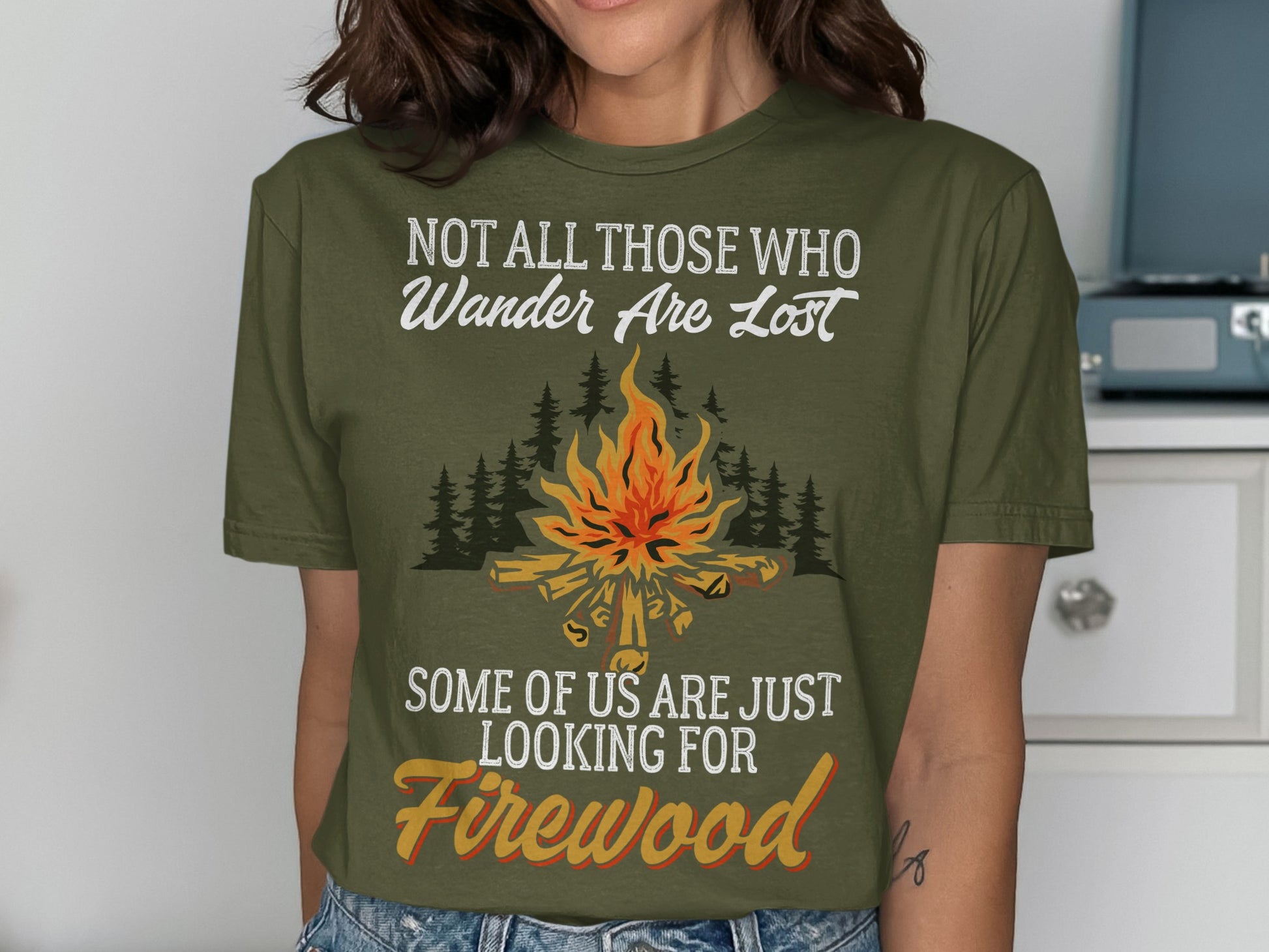 Green t-shirt with campfire graphic and text "Not all those who wander are lost"