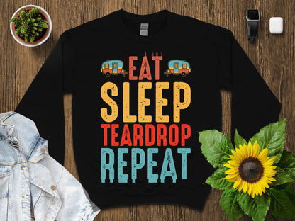 Black sweatshirt with "Eat Sleep Teardrop Repeat" text and camping graphics.