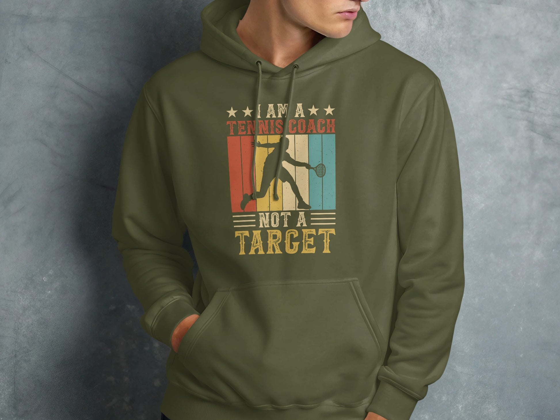 Green hoodie with "I Am A Tennis Coach, Not A Target" text and retro graphic.