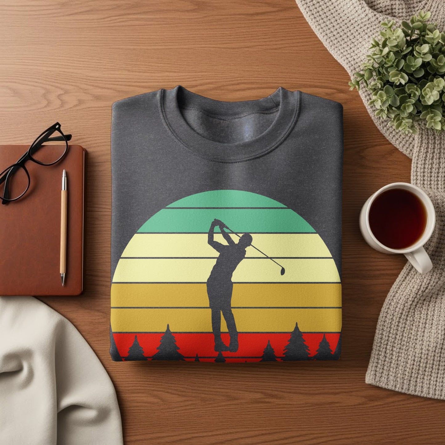 Dark grey sweatshirt with a golfer silhouette against a vintage sunset and pine trees.