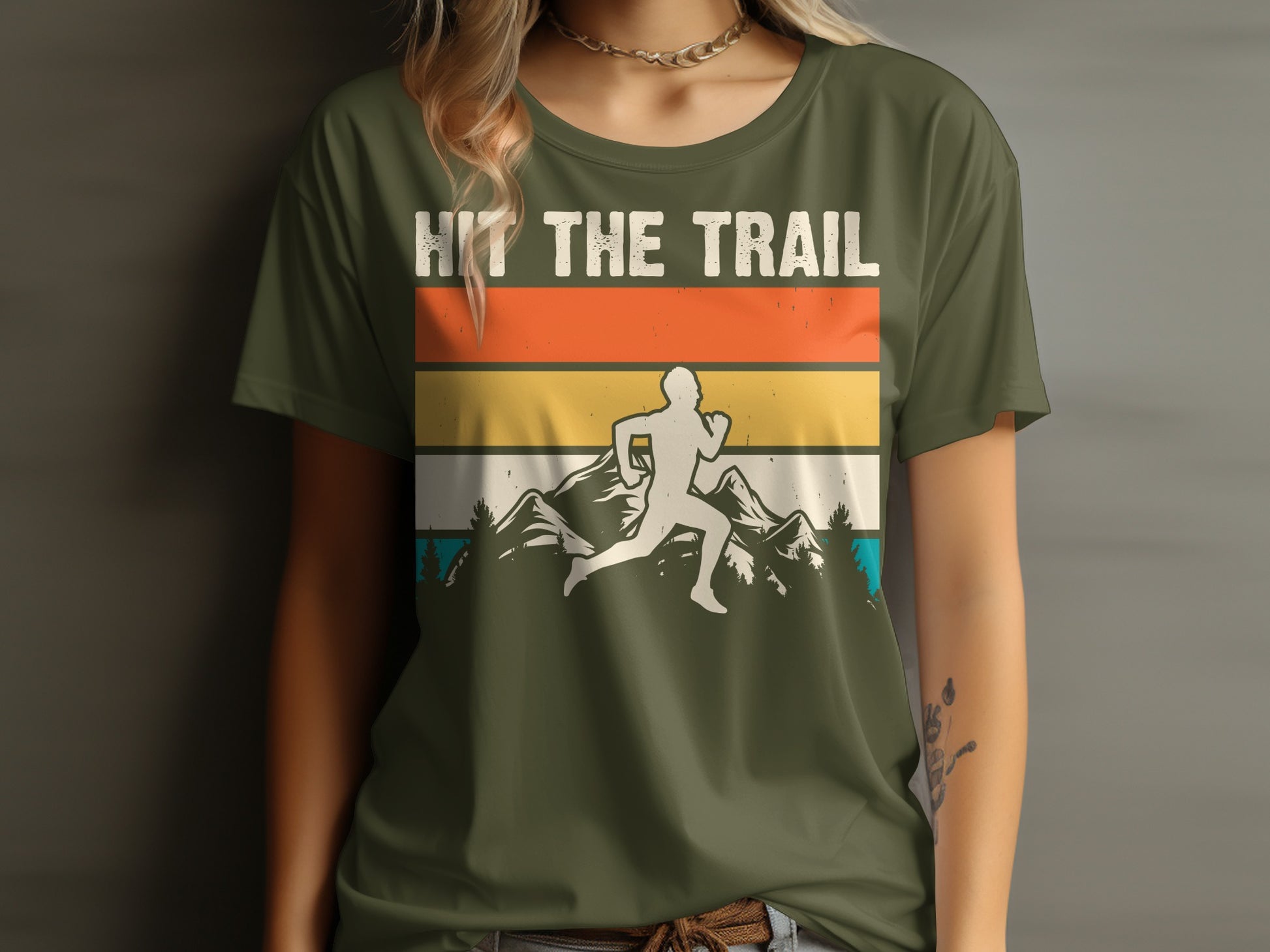 Olive green t-shirt with graphic of runner and mountains, text "HIT THE TRAIL".