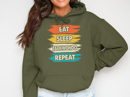 Green hoodie with "Eat Sleep Taekwondo Repeat" text in colorful stripes.