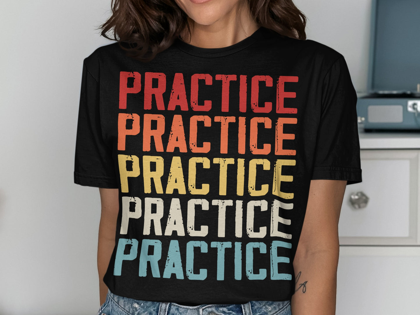 Black t-shirt with "PRACTICE" printed five times in rows of red, orange, yellow, white, and blue.