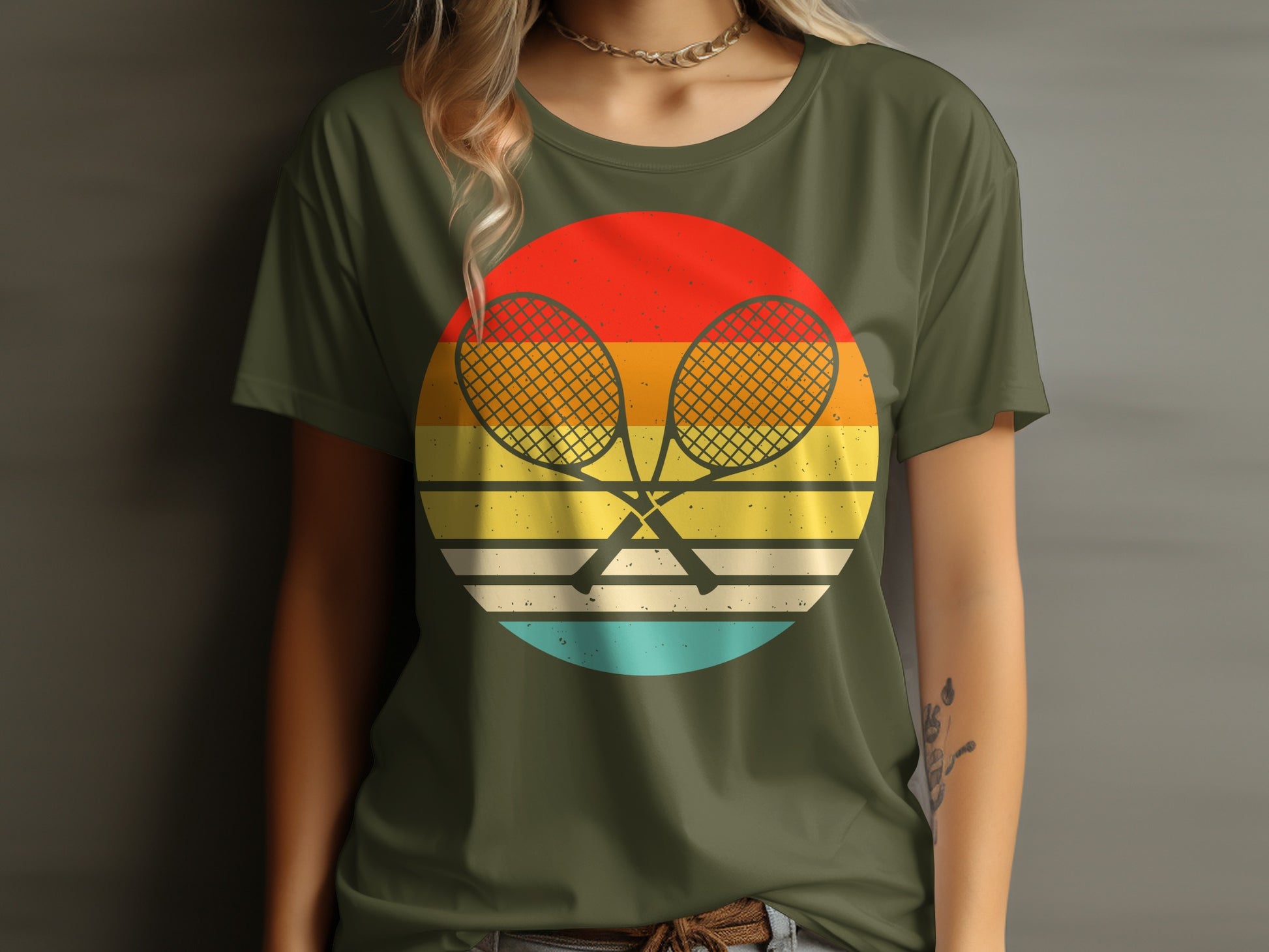 Green t-shirt with crossed tennis rackets on a retro sunset graphic.