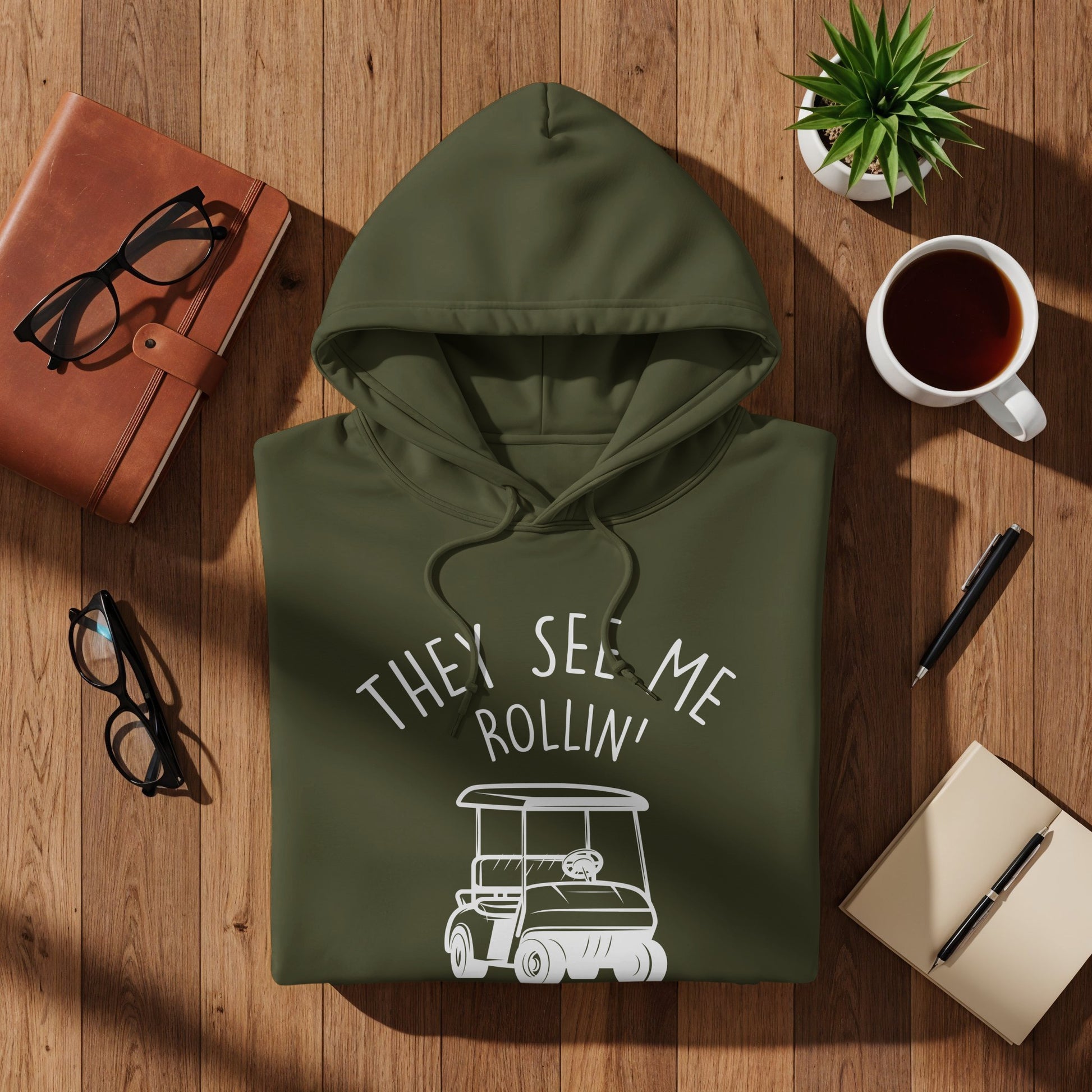 Olive green hoodie with "They See Me Rollin'" and a golf cart graphic.