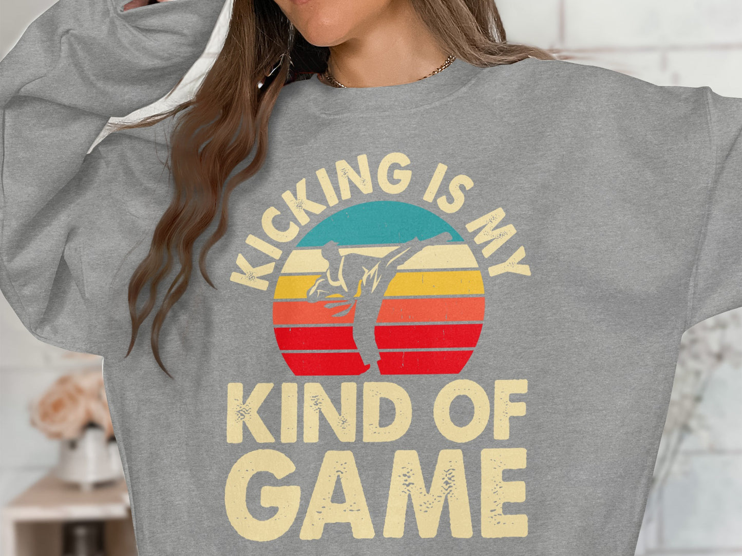 Grey sweatshirt with "KICKING IS MY KIND OF GAME" and sunset karate graphic.