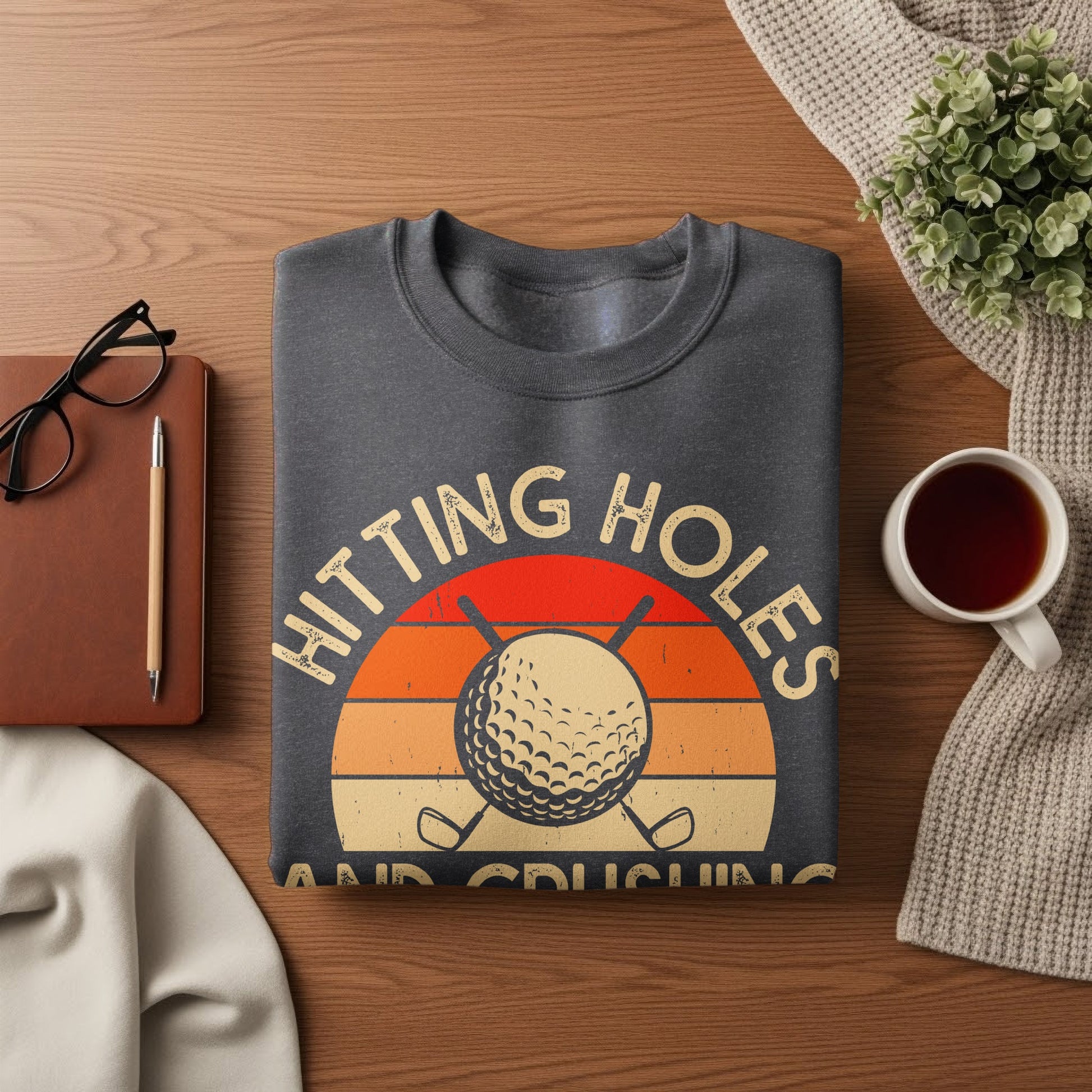 Dark grey sweatshirt with "Hitting Holes" text and golf ball graphic.