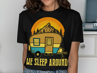 Black t-shirt with a graphic of a camper, mountain, and trees, and text "WE SLEEP AROUND".