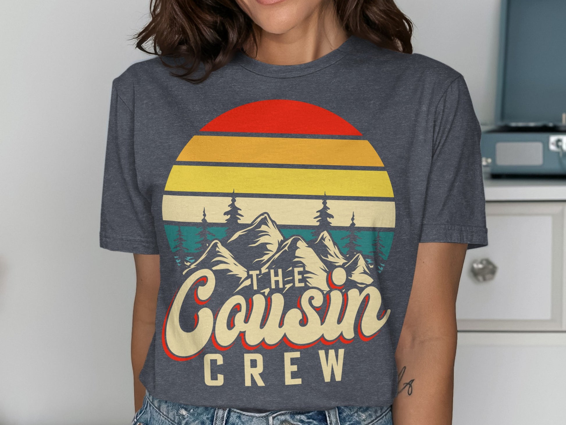 Graphic tee with sunset, mountains, and "The Cousin Crew" text.