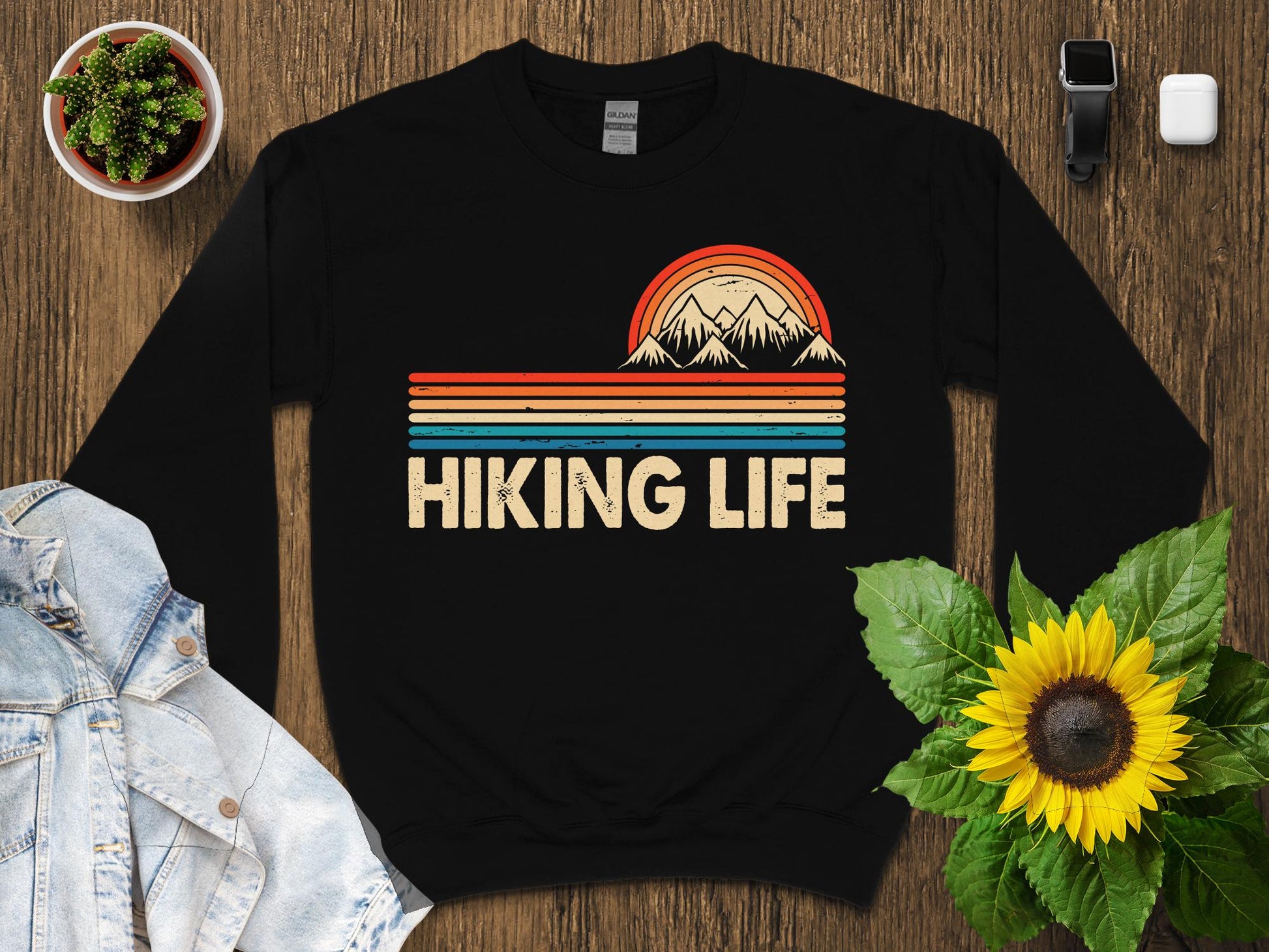 Retro sunset over mountains with "Hiking Life" text on a black sweatshirt.