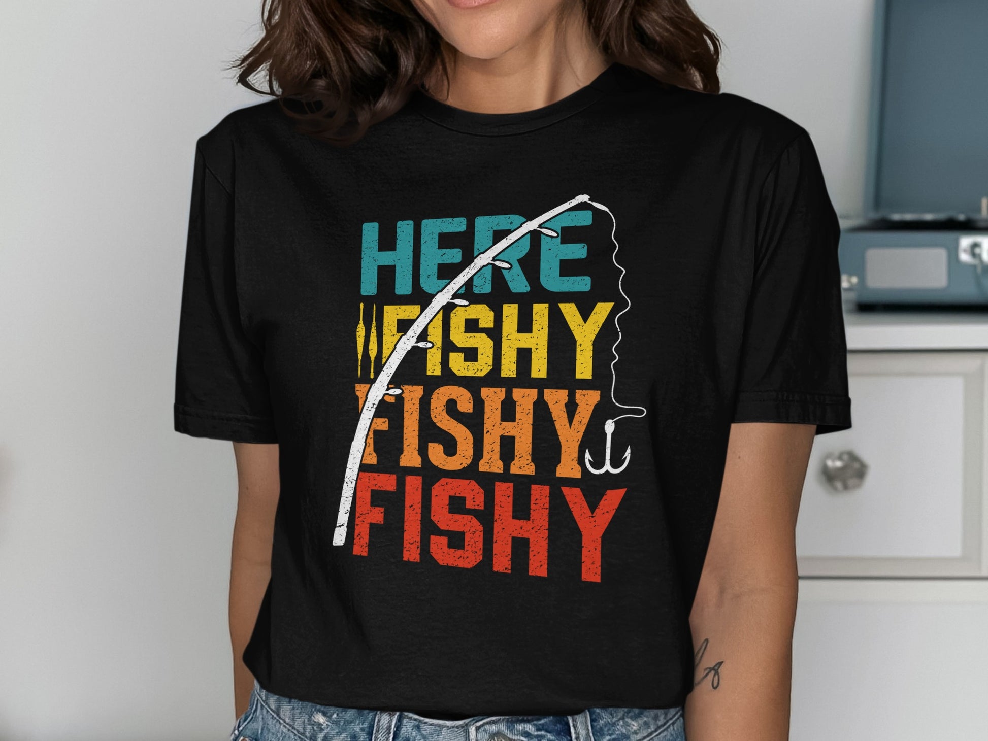 Black t-shirt with "HERE FISHY FISHY FISHY" text and fishing rod graphic.