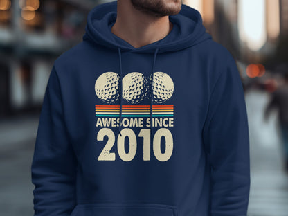 Navy hoodie with "Awesome Since 2010" text and three golf balls.