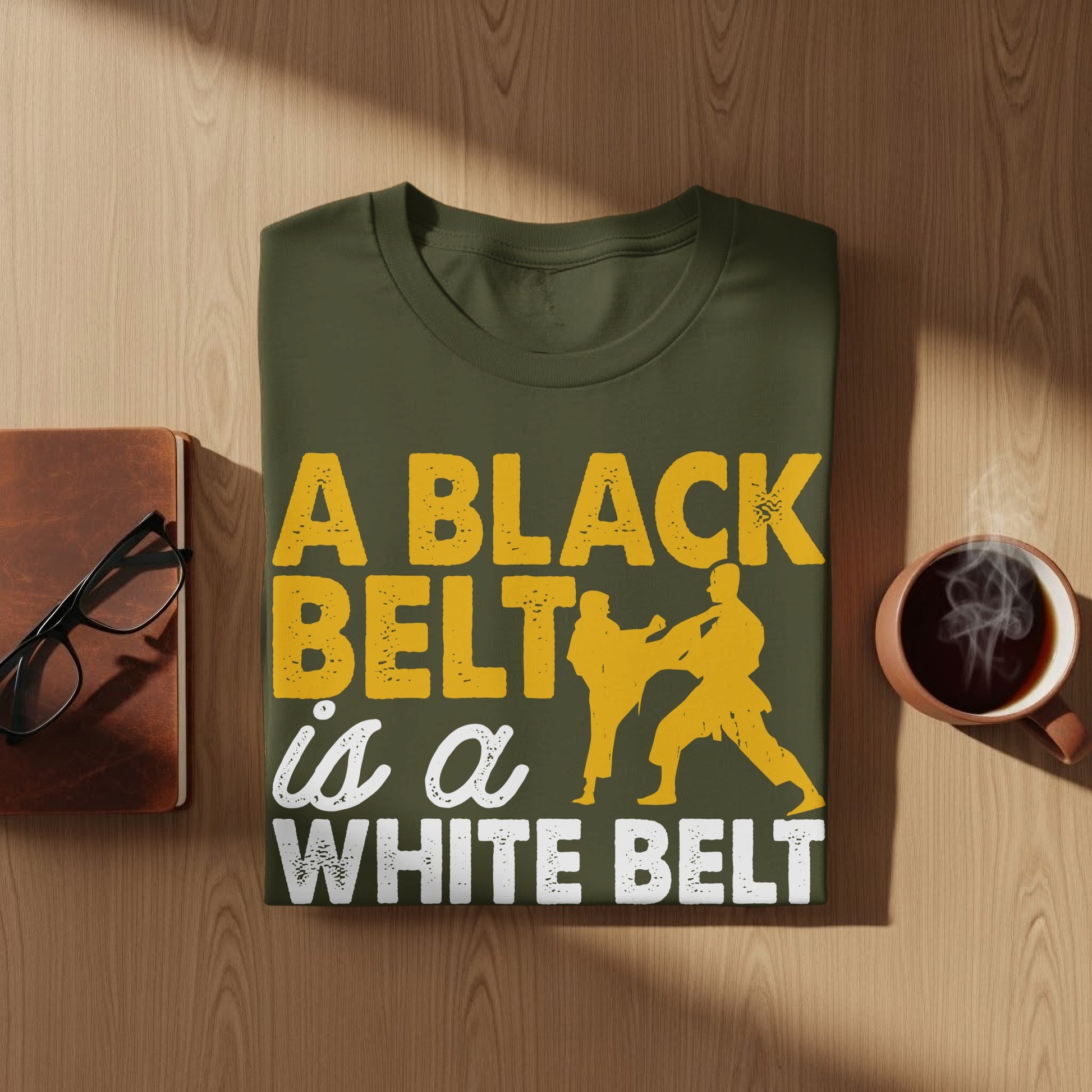 Olive green t-shirt with yellow text about black belts and white belts.
