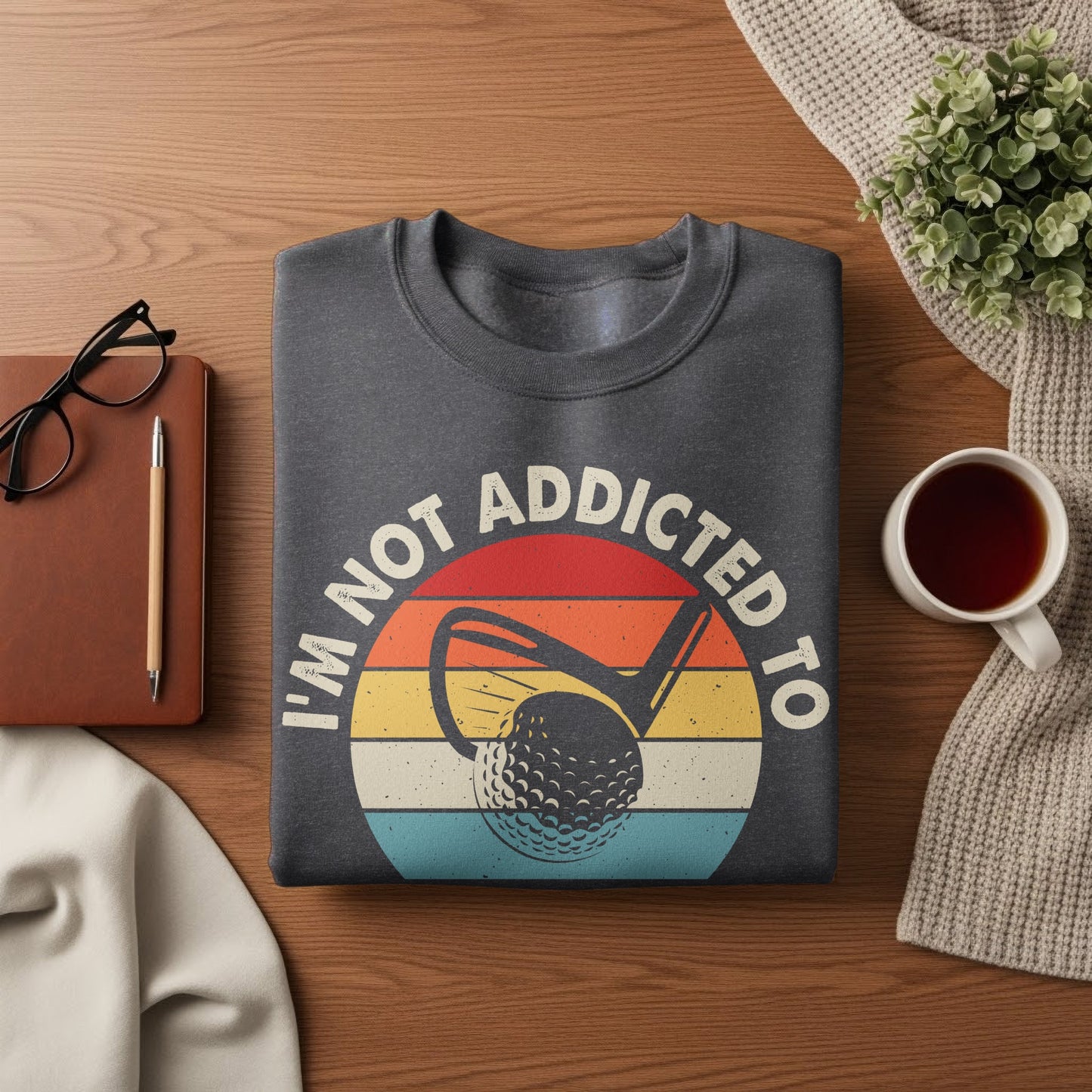 Dark grey sweatshirt with "I'm not addicted to golf" text and golf ball graphic.