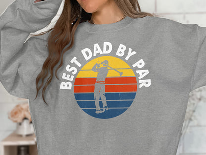 Gray sweatshirt with "BEST DAD BY PAR" text and a golfer in a retro sunset graphic.