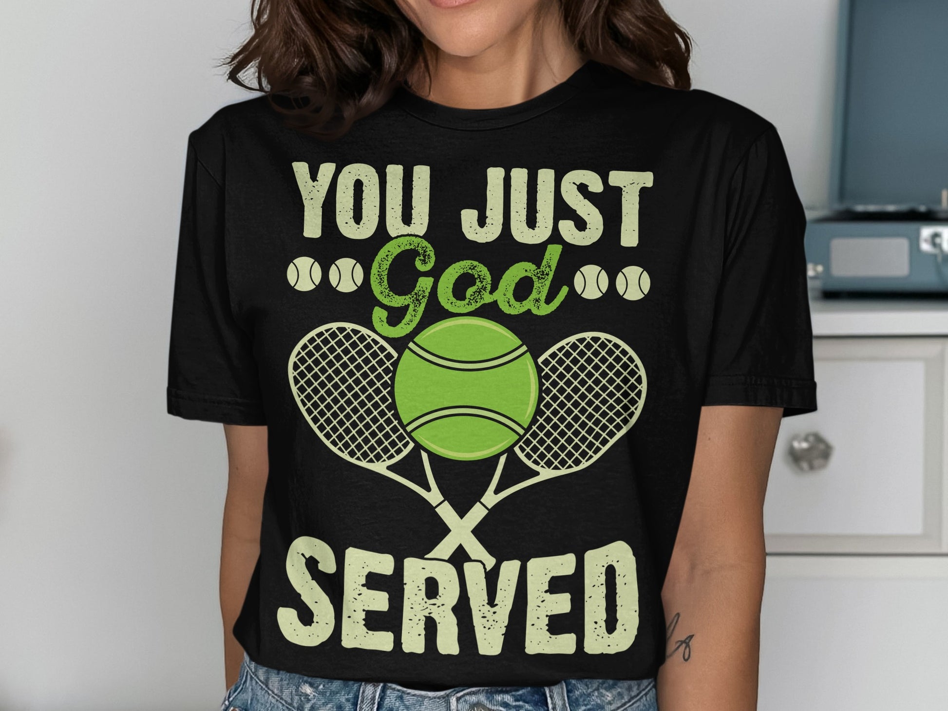 Black t-shirt with "YOU JUST God SERVED" text and tennis rackets and balls.