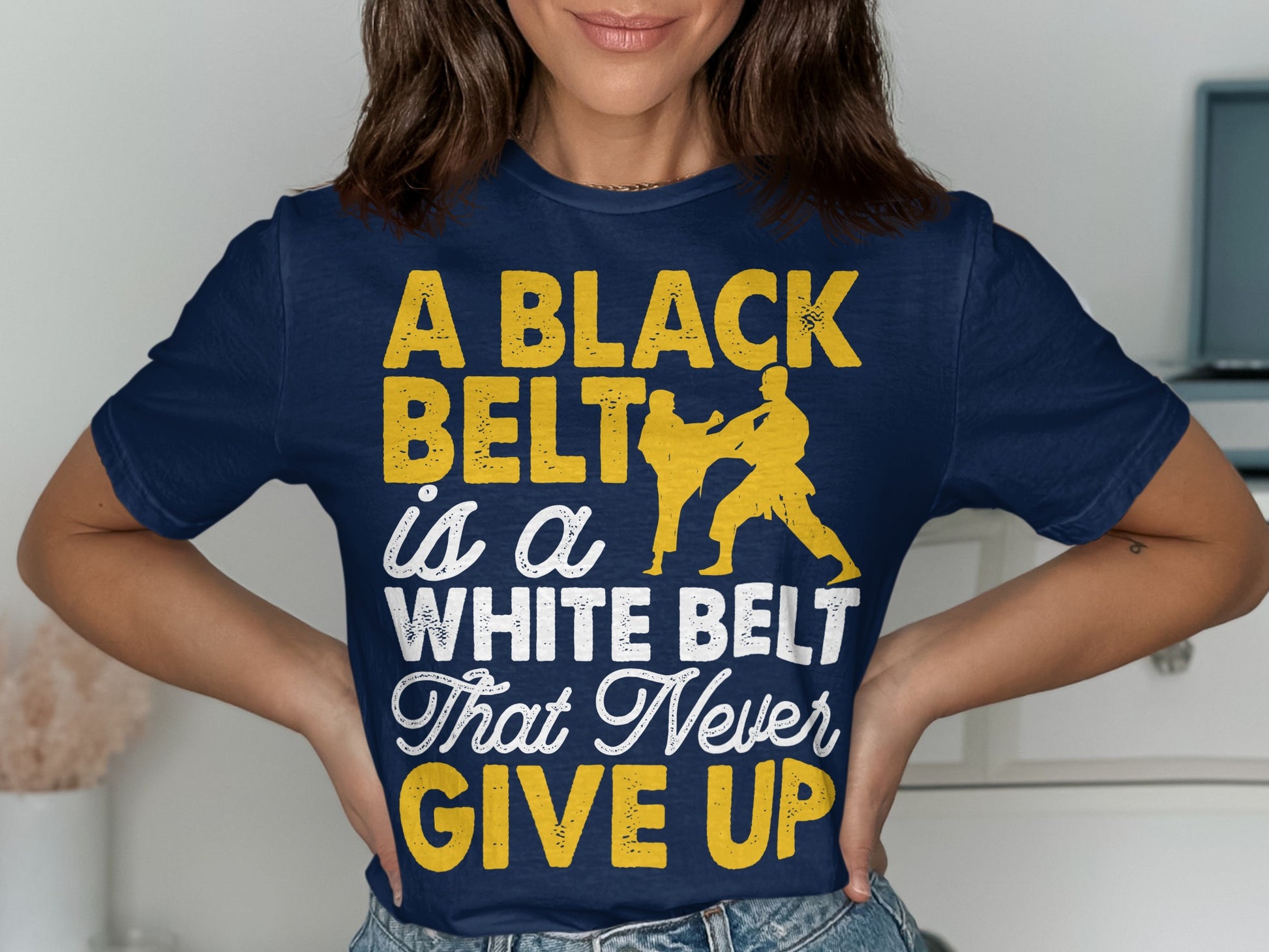 Navy t-shirt with yellow text: "A BLACK BELT is a WHITE BELT That Never GIVE UP" and martial arts figures.