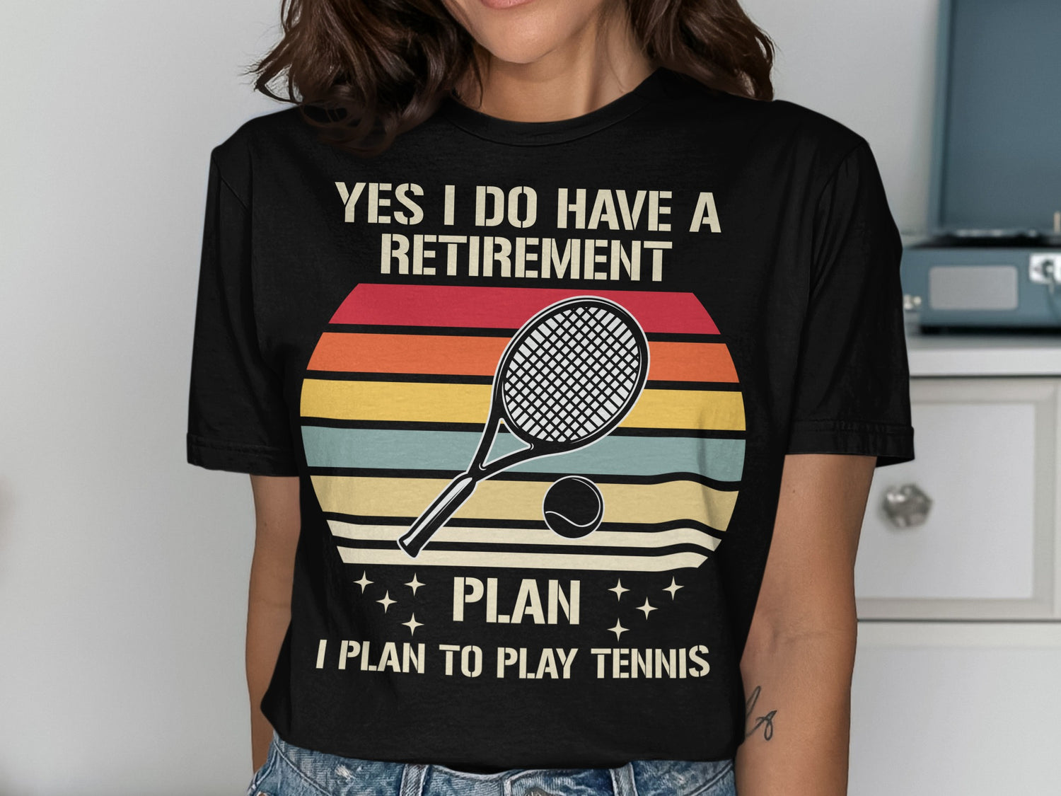 Black t-shirt with a retro sunset graphic and the text "YES I DO HAVE A RETIREMENT PLAN I PLAN TO PLAY TENNIS".