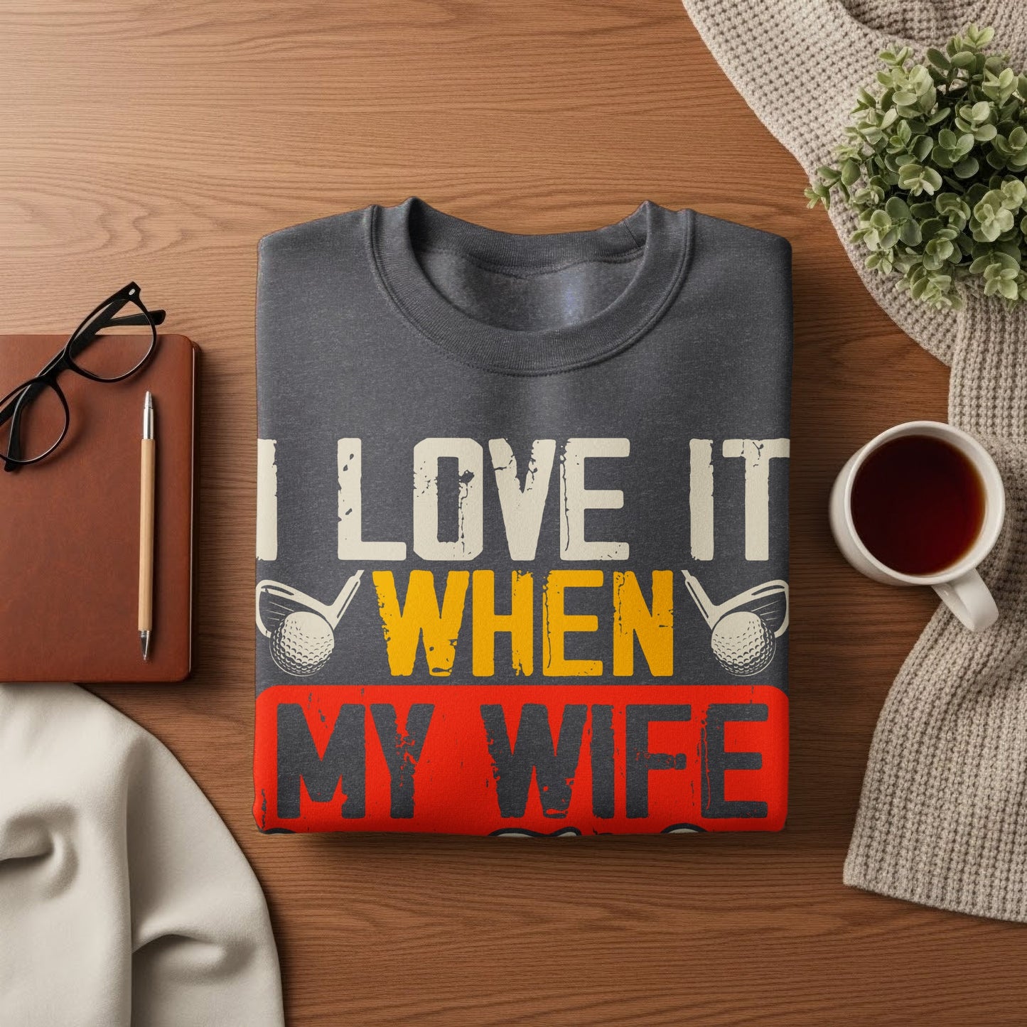 Dark gray sweatshirt with "I LOVE IT WHEN MY WIFE" text and golf imagery.