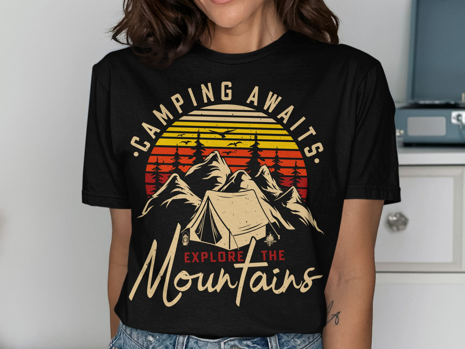 Vintage camping graphic t-shirt with tent, mountains, and "Camping Awaits Explore the Mountains" text.
