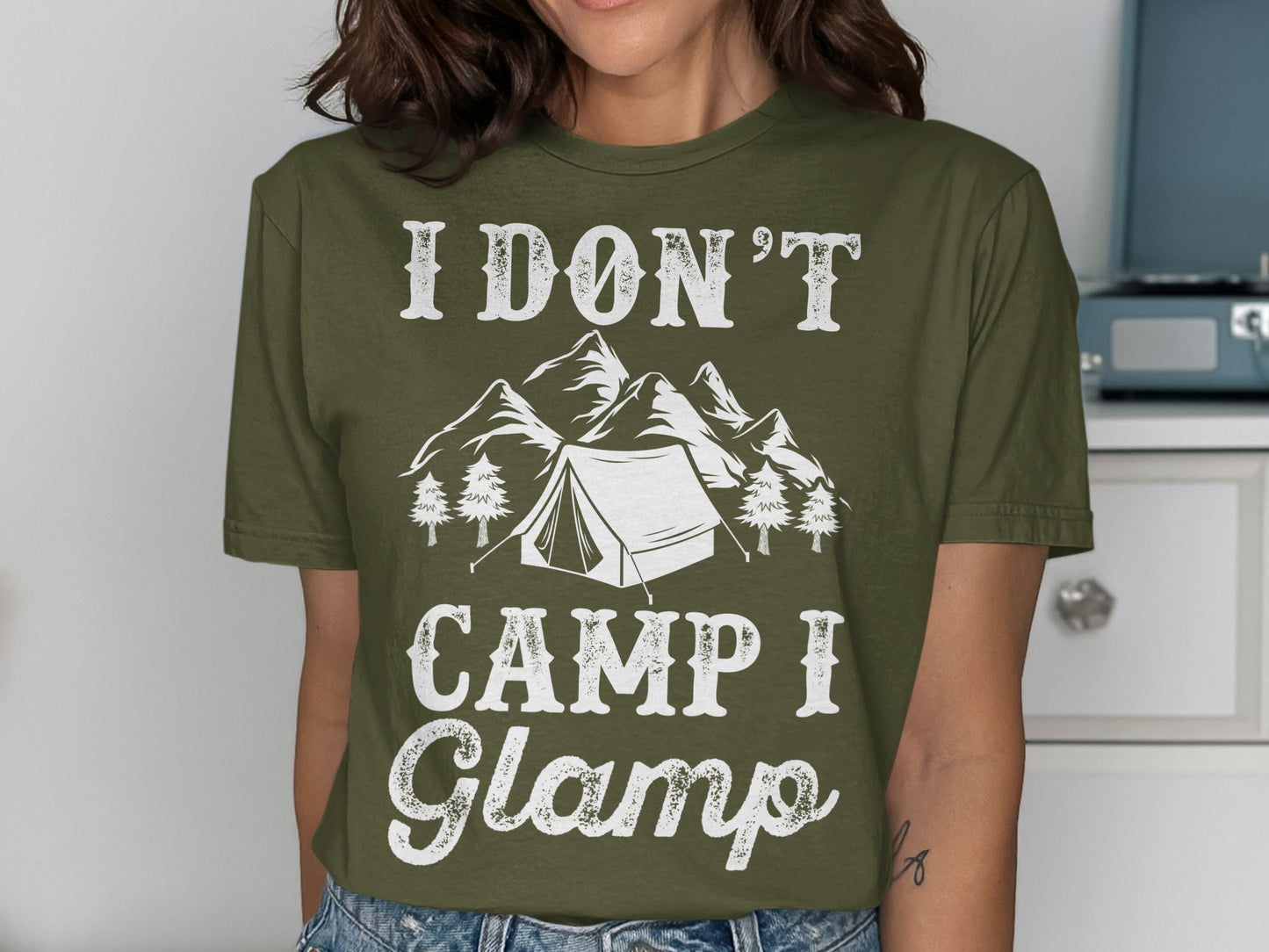 Olive t-shirt with "I don't camp I glamp" text and mountain tent graphic.